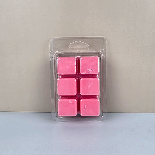 Pack of pink wax melts in clear packaging on a light gray background