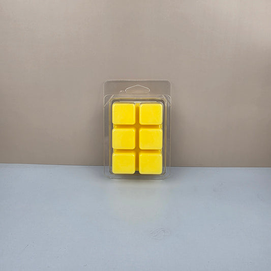 Pack of six yellow wax cubes in clear packaging on a neutral background
