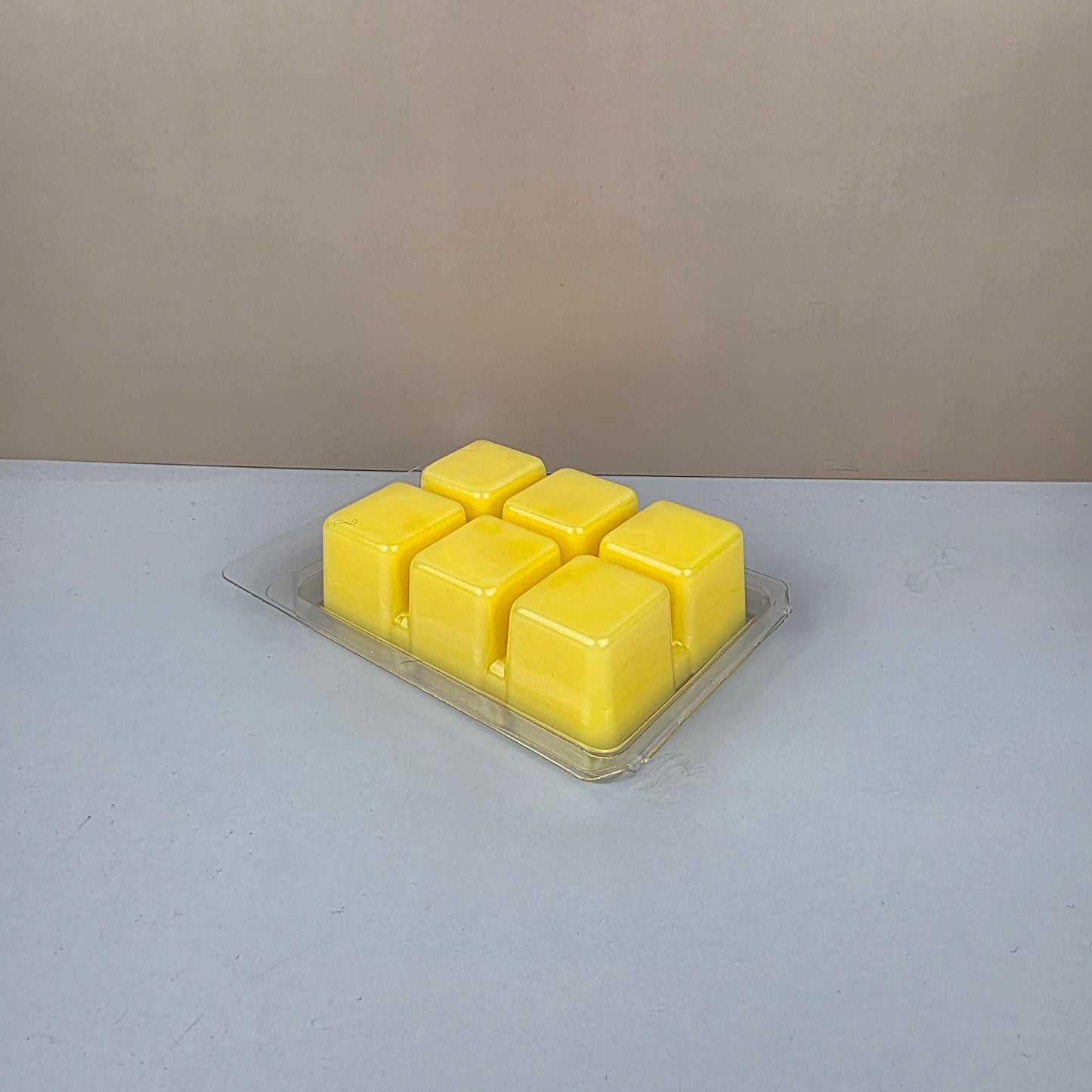 Pack of yellow wax melts on a gray surface