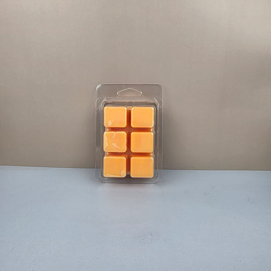Pack of yellow wax cubes in clear plastic packaging on a gray background