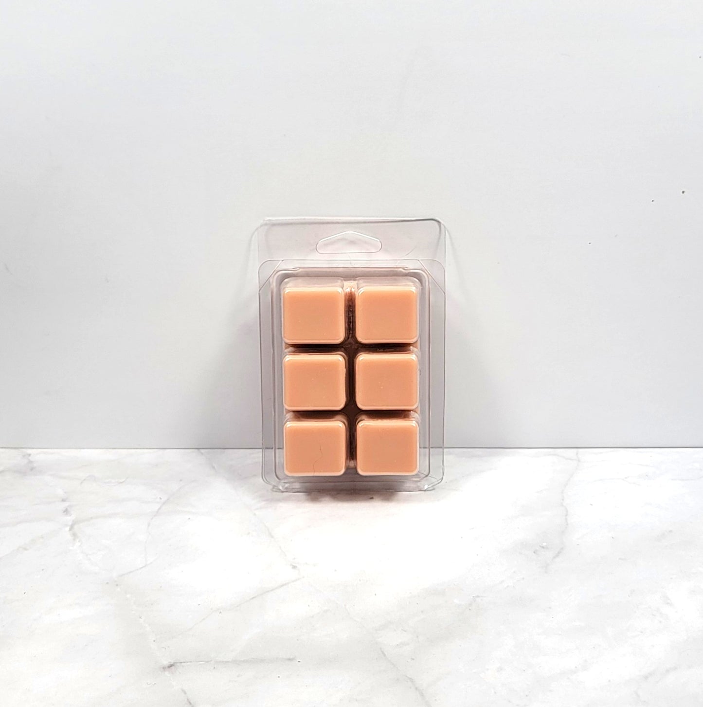 Vanilla and cinnamon wax melt cubes next to a plate of holiday cookies