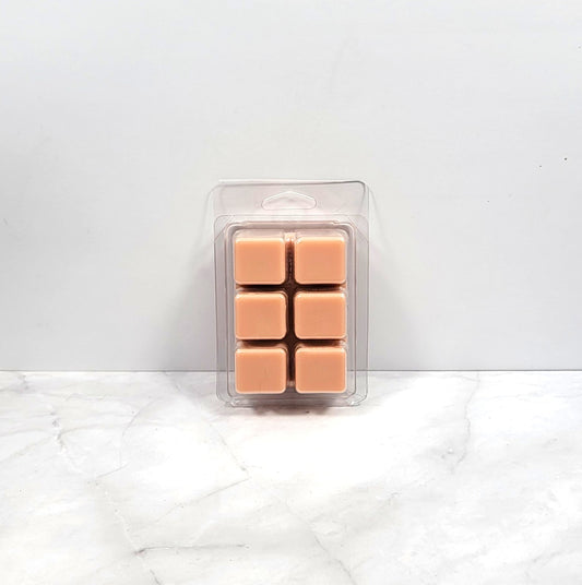 Vanilla and cinnamon wax melt cubes next to a plate of holiday cookies