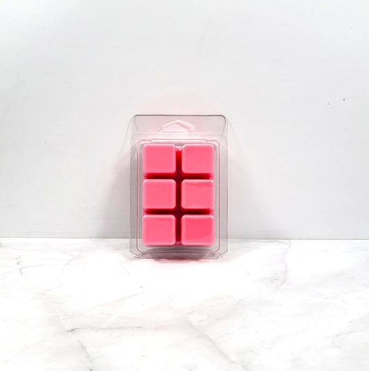 Pink wax melts in a clear plastic packaging on a white background
