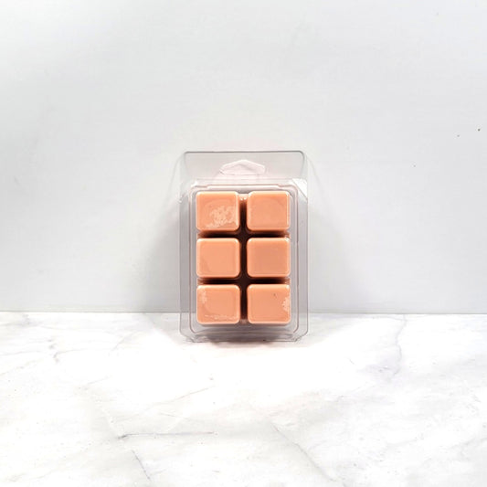 Pack of tan-colored wax melts in a clear plastic packaging on a white background