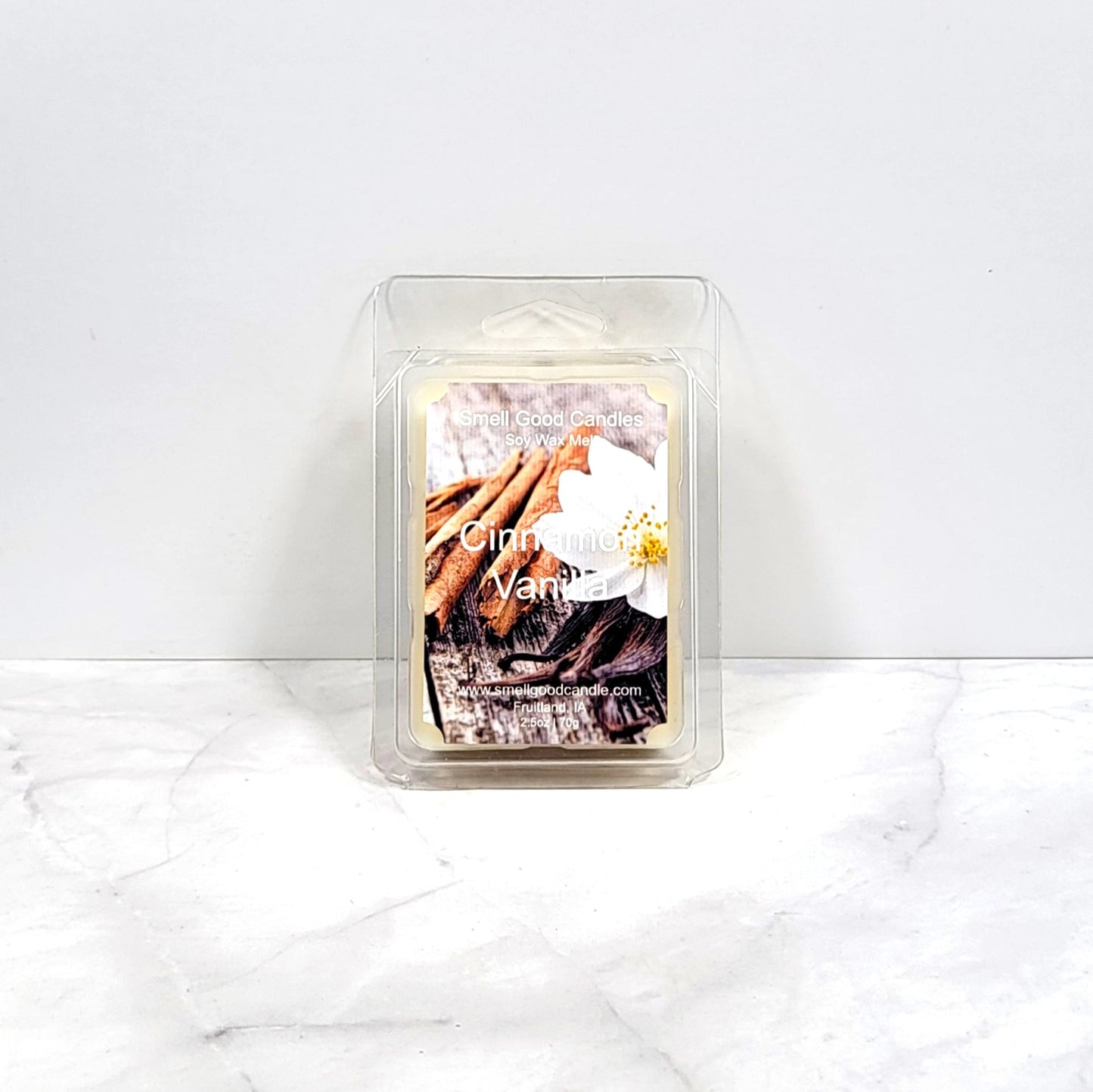 Cinnamon Vanilla soy wax melt beside cinnamon sticks and vanilla pods