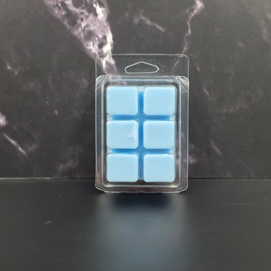 Packaged blue wax melts on a dark marble surface