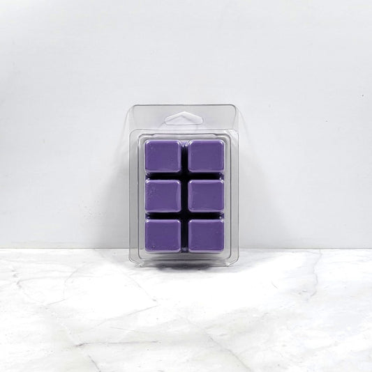 Pack of purple wax melts in clear packaging on a white marble surface