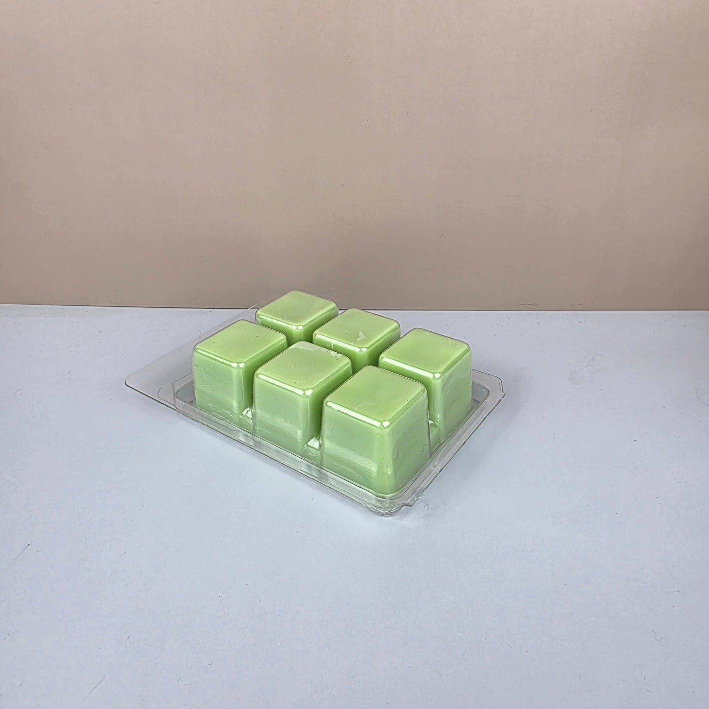 Pack of green wax melts on a white background