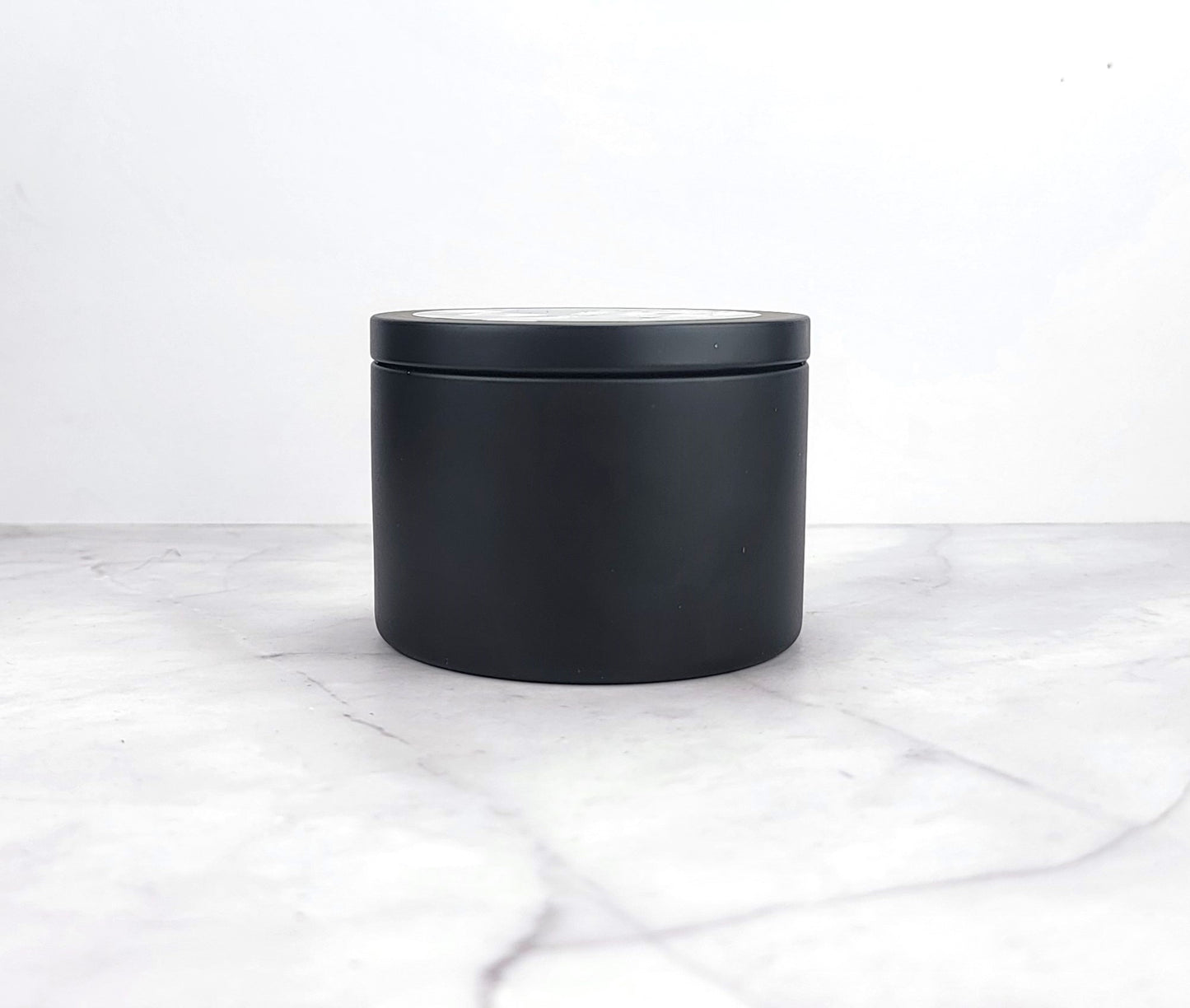 Close-up of soy wax candle with floral fragrance elements.