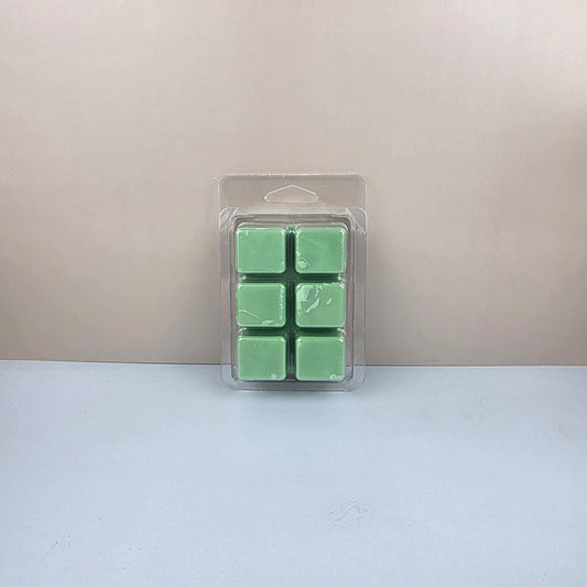 Pack of six green wax melts in a clear plastic packaging on a light gray background