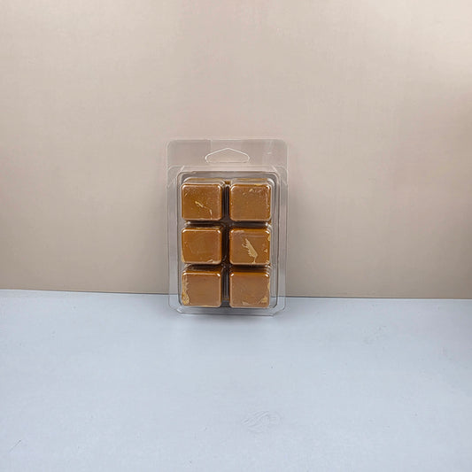 Pack of six brown wax melts in a clear plastic packaging on a light gray background