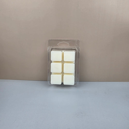 Pack of white wax melts in a clear plastic packaging against a gray background