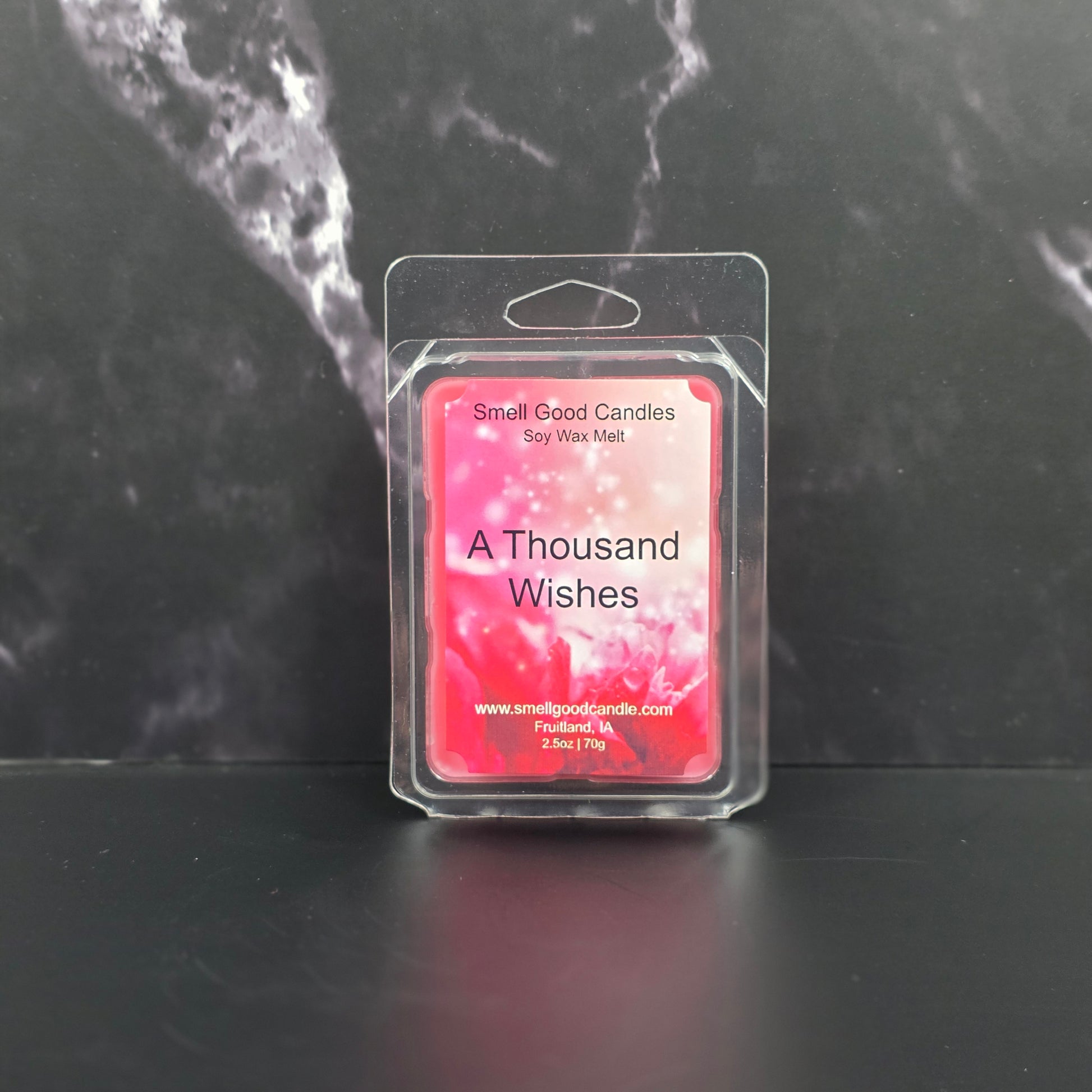 Wax melt package labeled 'A Thousand Wishes' on a dark marble surface