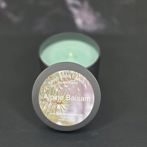 Hand-poured Alpine Balsam soy wax candle by Smell Good Candles — a refreshing pine and balsam Christmas scent in a matte black jar with green wax.