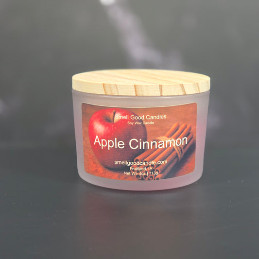 Apple Cinnamon candle with a label on a reflective surface