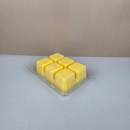 Pack of yellow wax cubes in a clear plastic packaging on a gray background