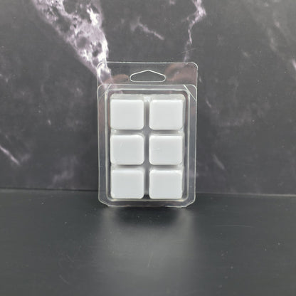 Pack of six gray wax melts in clear packaging on a dark marble background