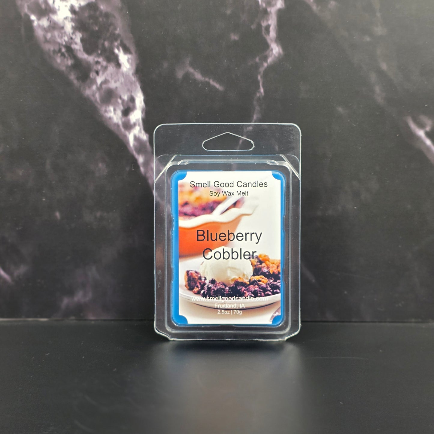 Blueberry Cobbler scented wax melt package on a dark marble surface