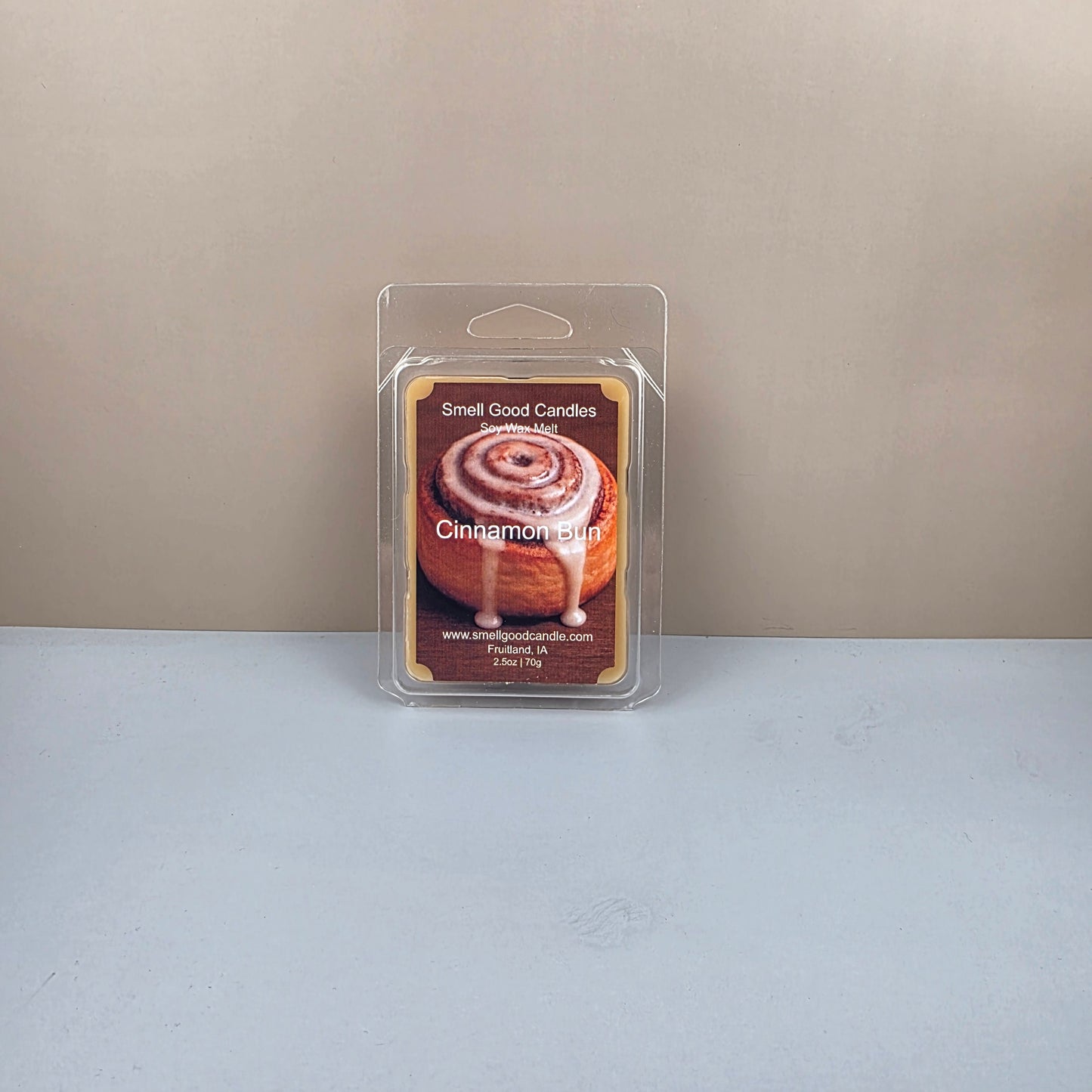 Packaged cinnamon bun wax melts on a neutral background