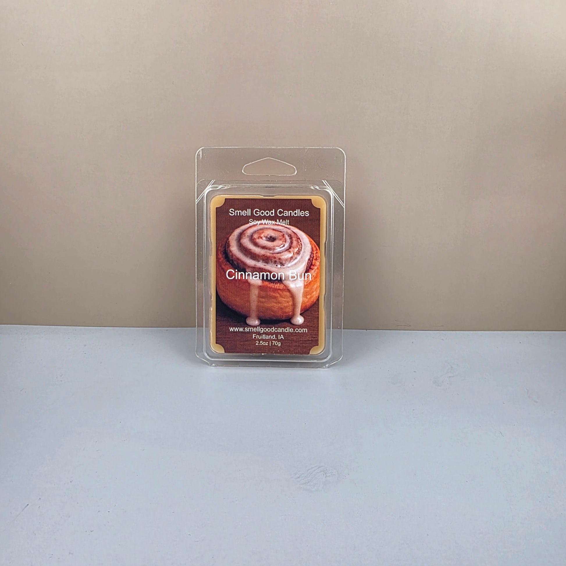Packaged cinnamon bun wax melts on a neutral background