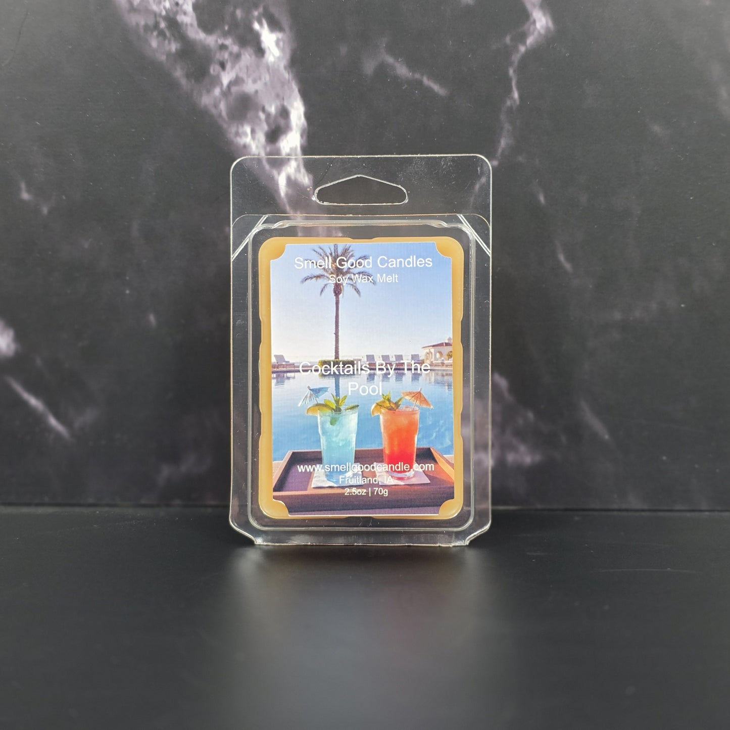 Packaged wax melt with cocktail-themed design on a dark marble background