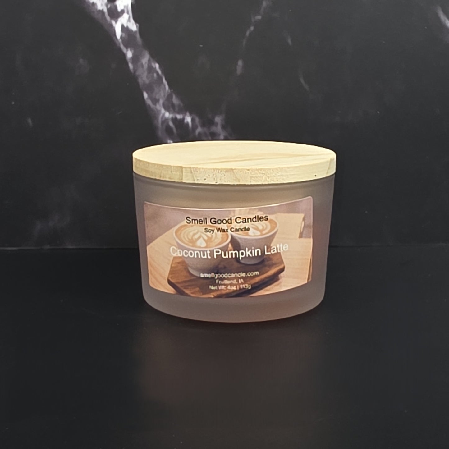 Coconut Pumpkin Latte candle with a wooden lid on a black background