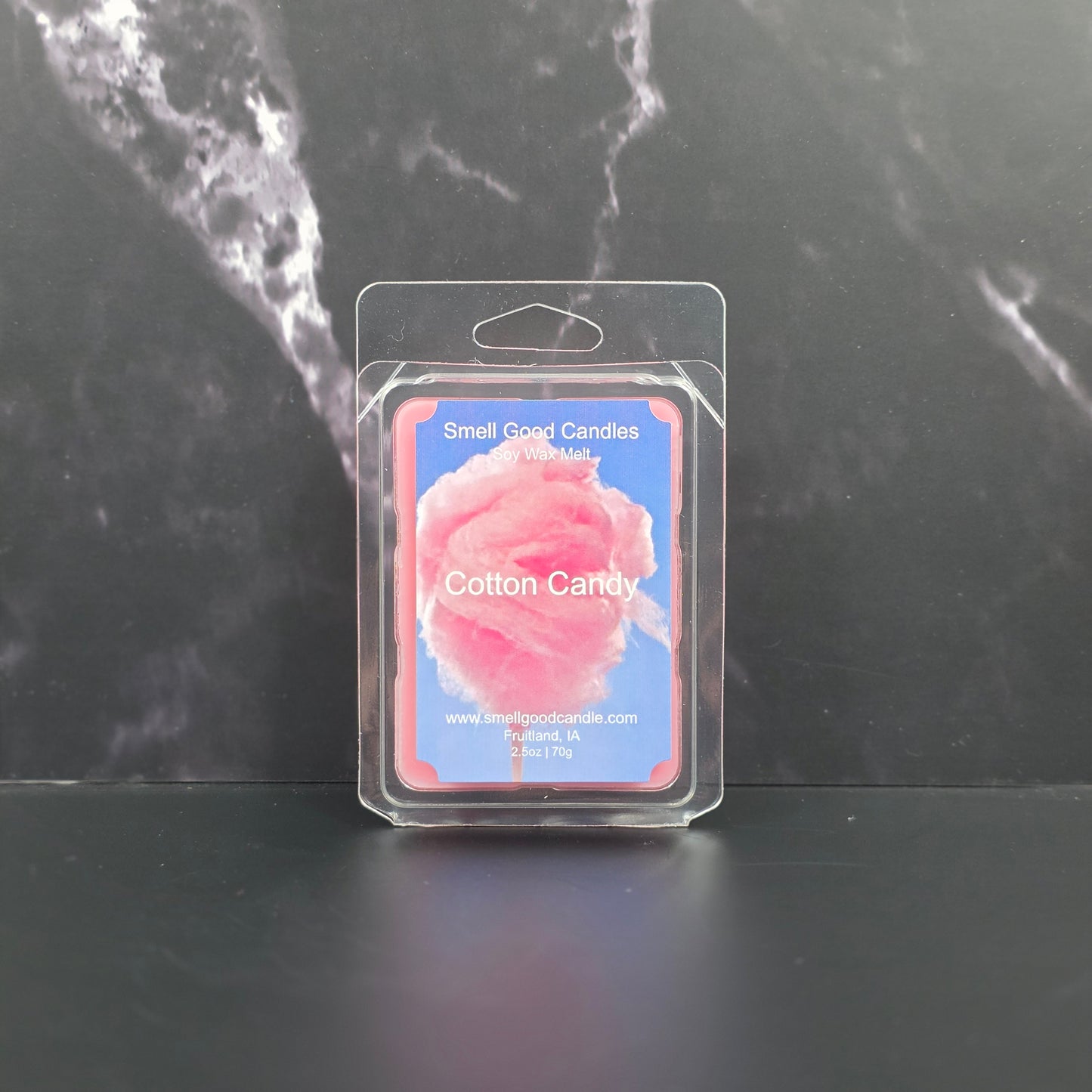 Cotton candy wax melt package on a dark marble surface