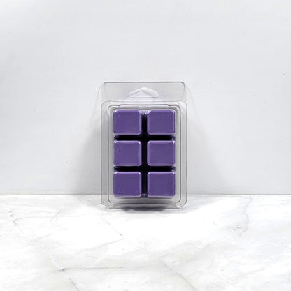 Pack of purple wax melts in clear packaging on a white marble surface