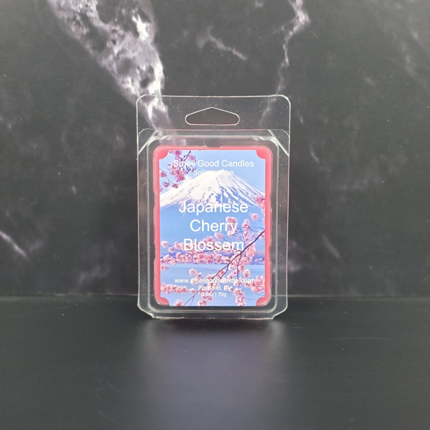Packaged candle labeled 'Japanese Cherry Blossom' on a dark background
