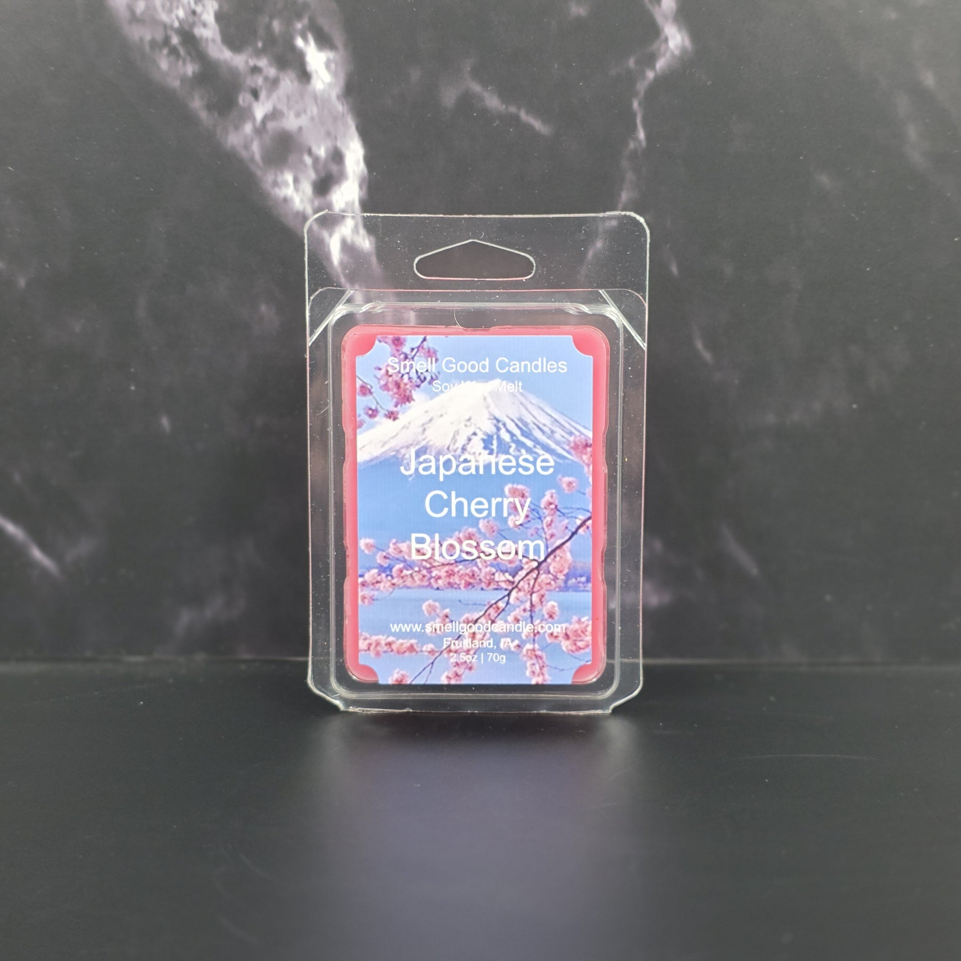 Packaged candle labeled 'Japanese Cherry Blossom' on a dark background