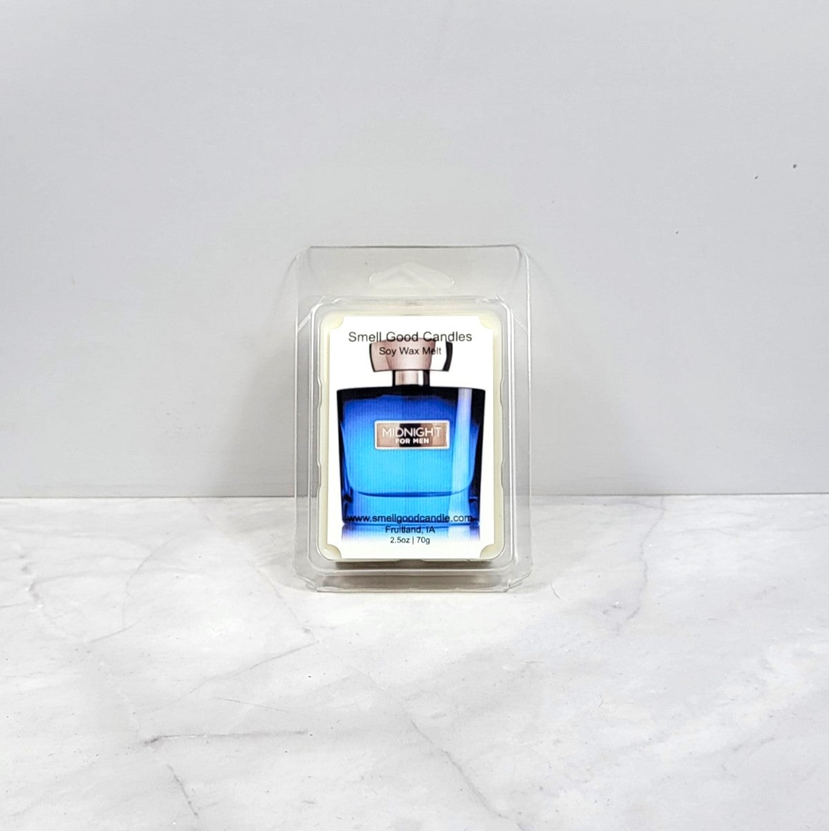Candle in a mold shaped like a blue bottle on a white surface