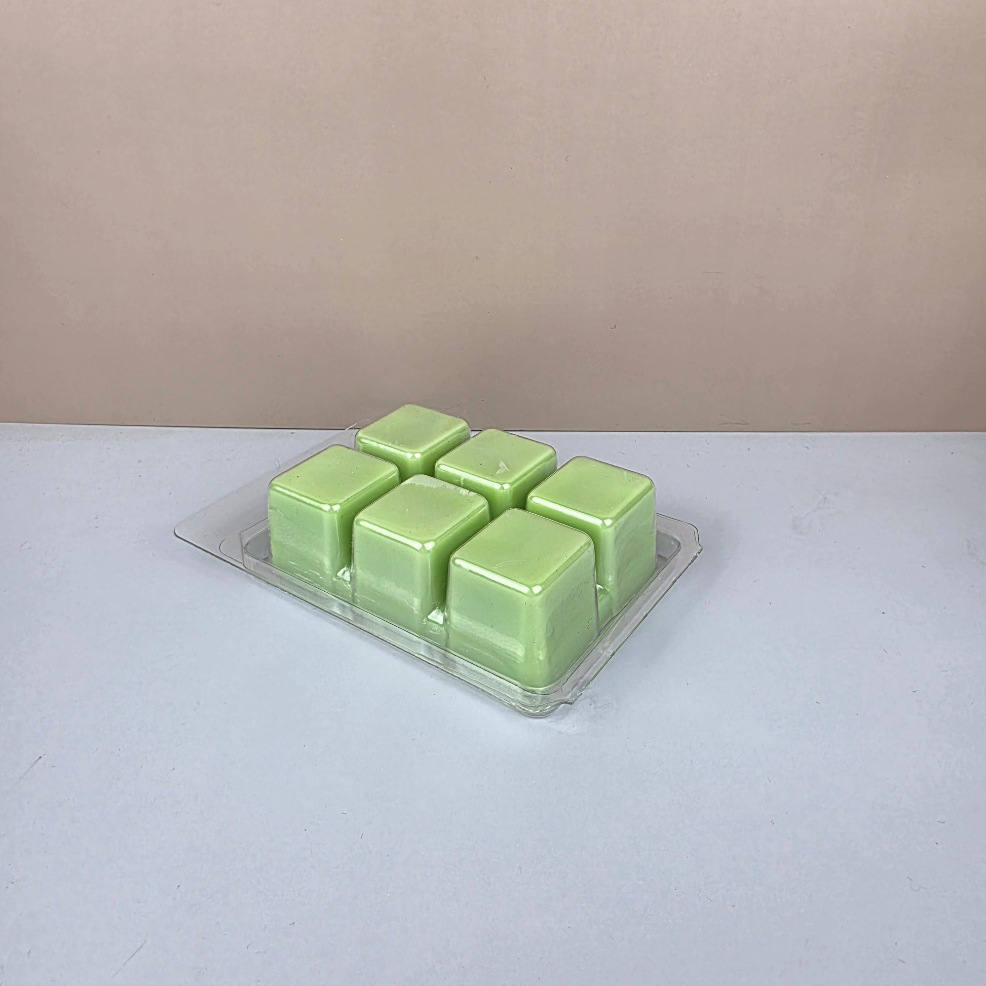 Pack of green wax melts on a white background