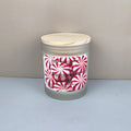 Frosted glass candle with peppermint label on a neutral background
