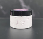 Whipped body lotion with lavender, pink sugar, and amber fragrance in a clear jar with a black lid
