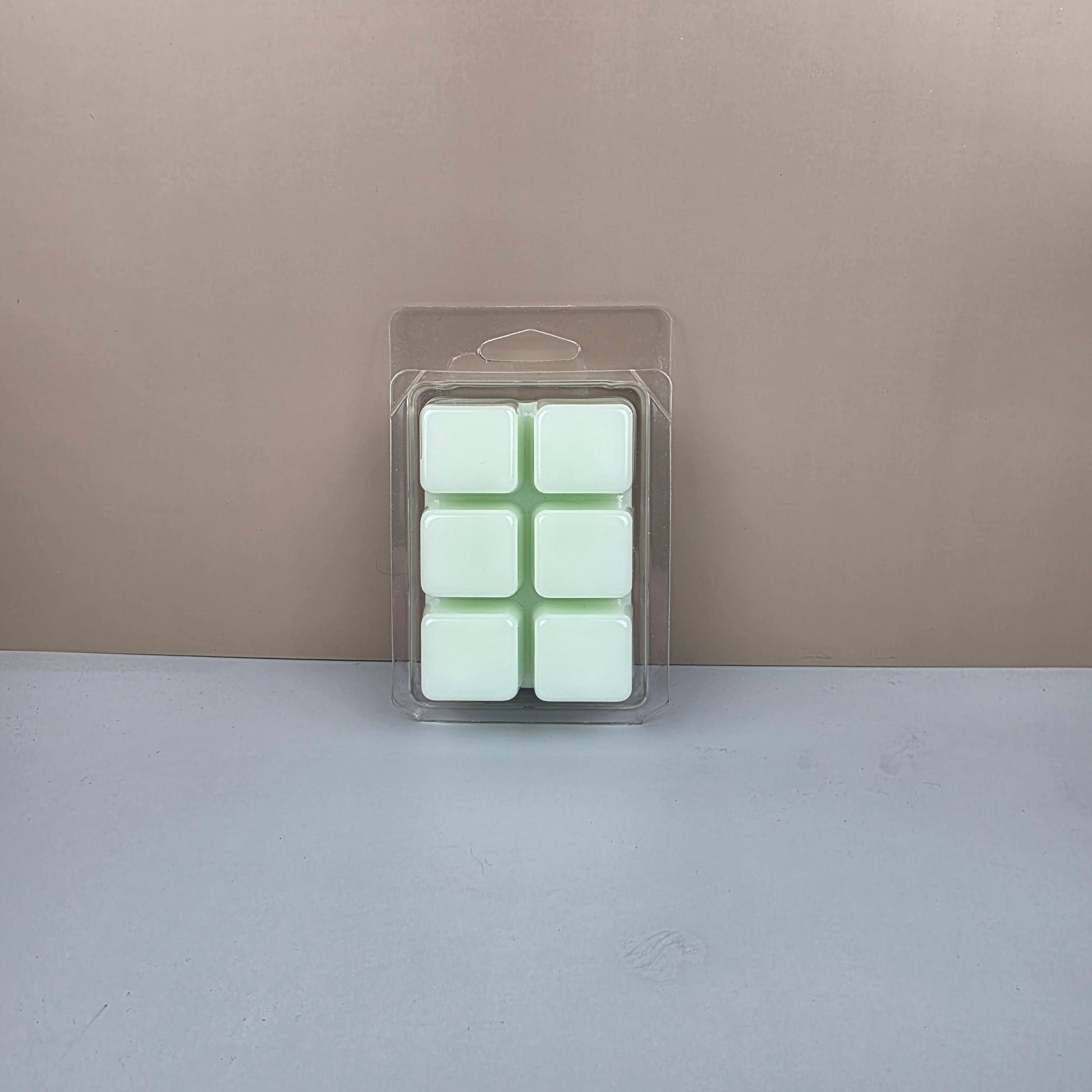 Packaged green wax melts on a neutral background