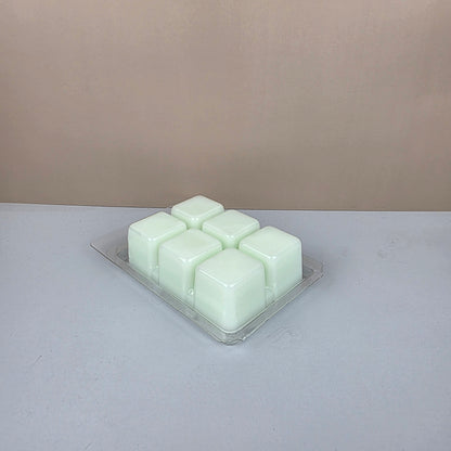 Hexagonal wax melts in a clear container on a light gray background