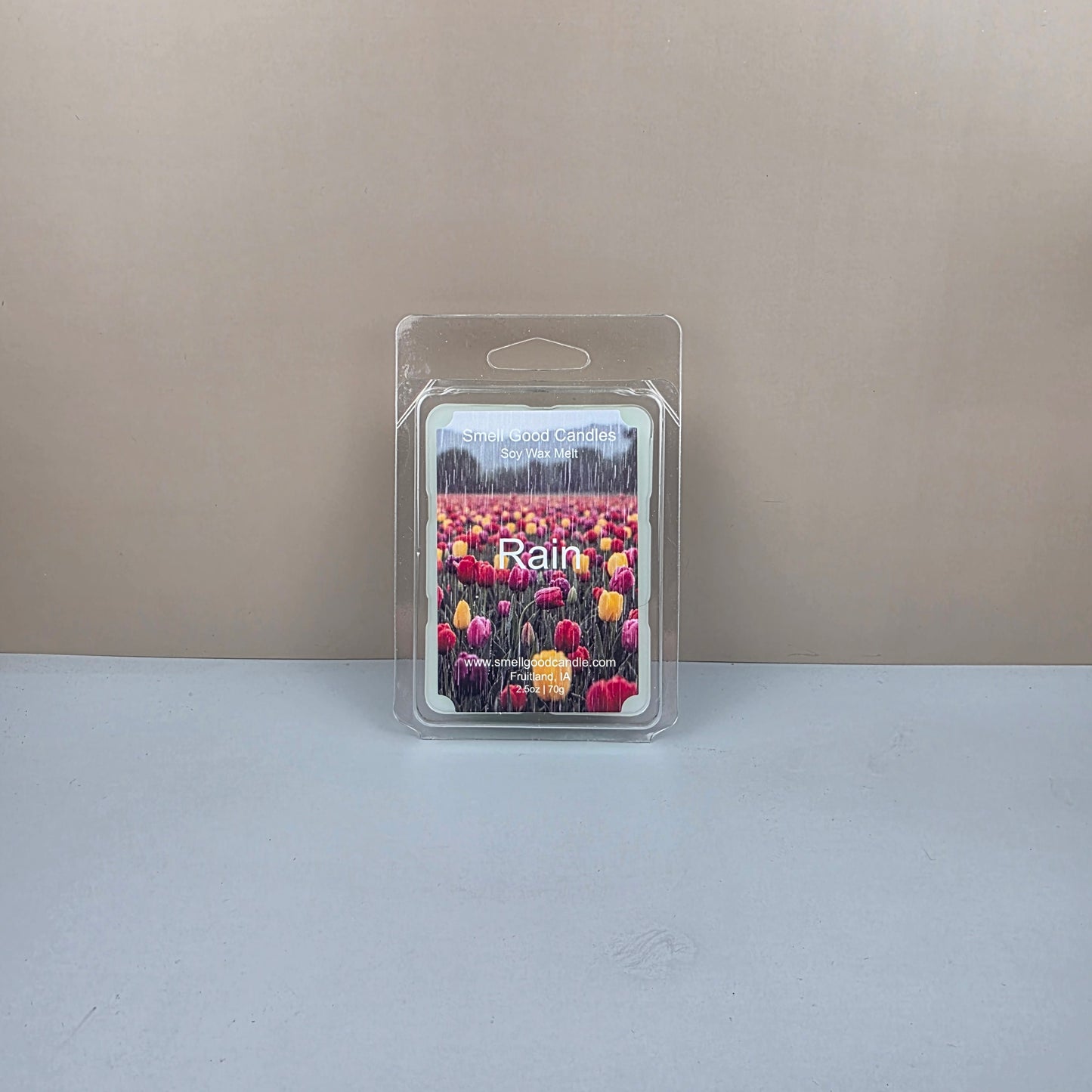 Packaged wax melt with floral design on a neutral background