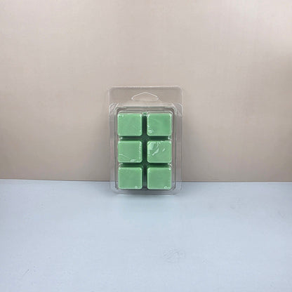 Pack of six green wax melts in a clear plastic packaging on a light gray background