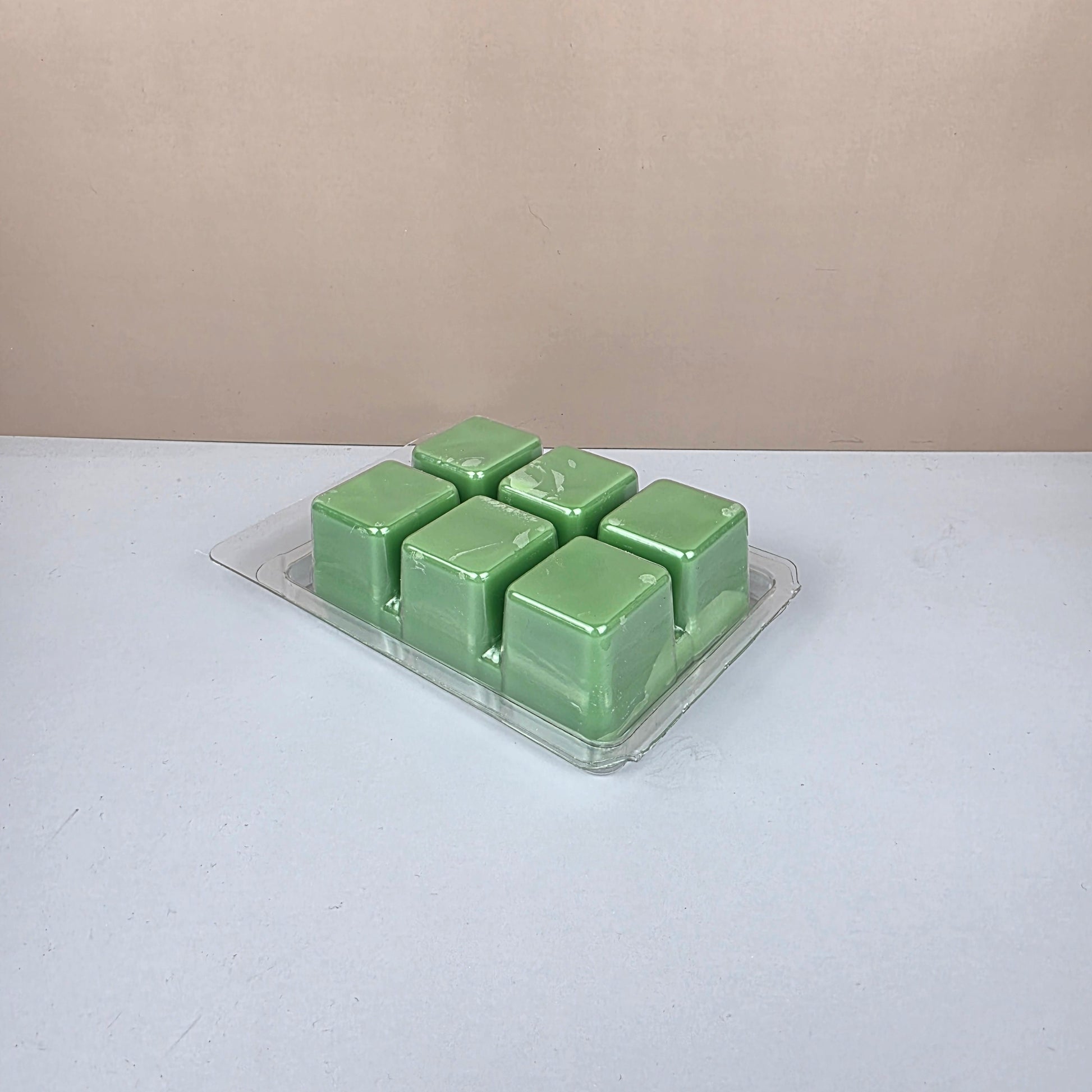 Pack of green wax melts on a white background
