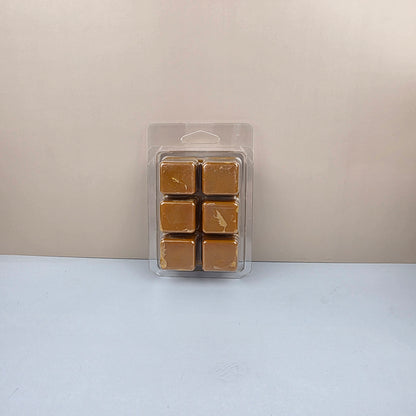 Pack of six brown wax melts in a clear plastic packaging on a light gray background