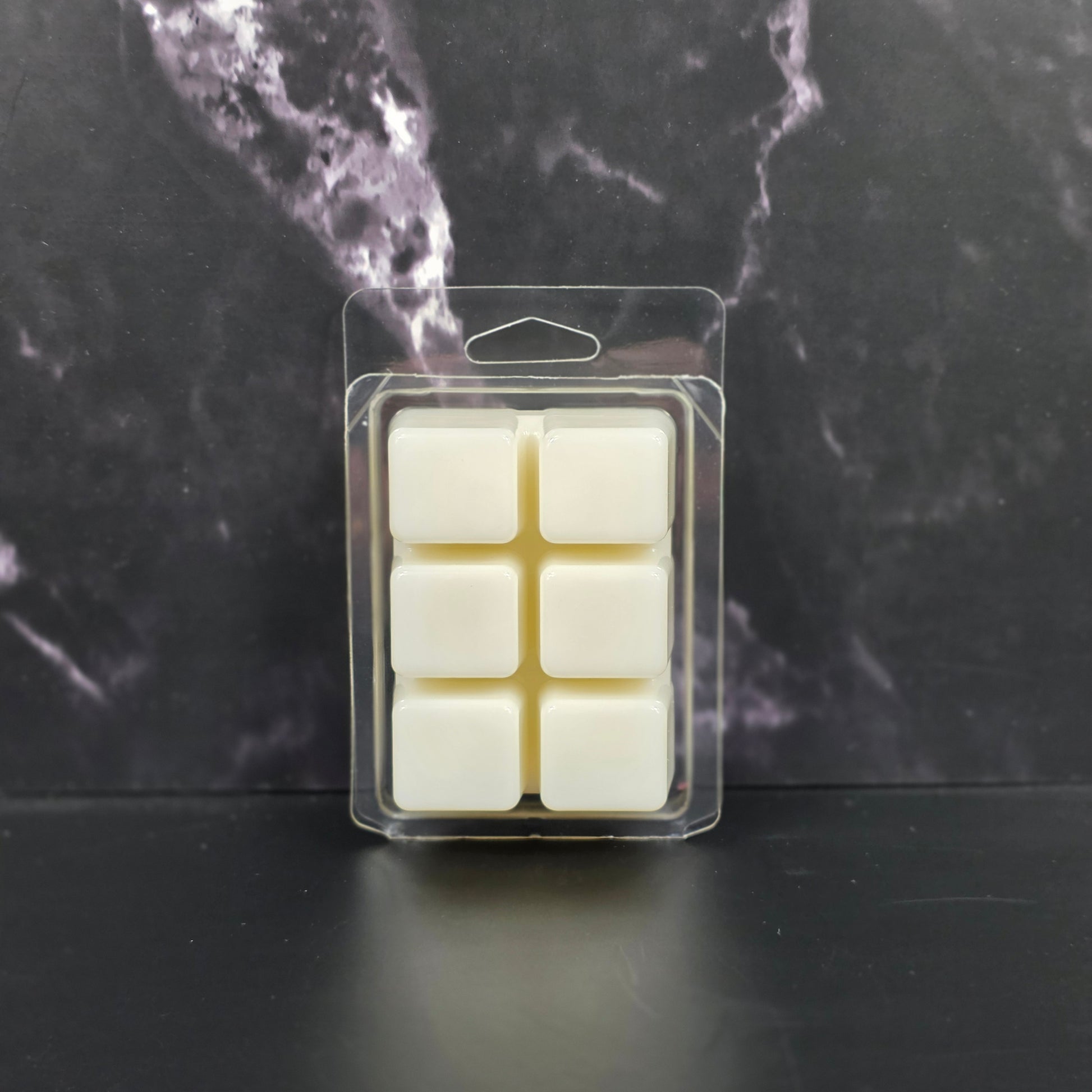 Packaged wax melts on a dark marble surface