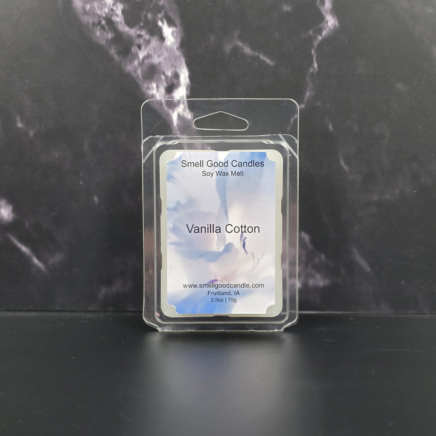 Packaged vanilla cotton soy wax melt with 'Smell Good Candles' label on a dark marble background